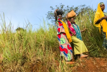 Afrikaanse vrouwen, altijd in kleurige gewaden en een last op het hoofd.