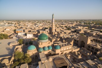 Op de voorgrond met het groene dak zie je het Pahlavon Mahmud Mausoleum met erachter de Islom-Hoja Minaret.
