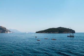 Massa's mensen die rond de oude stad kayakten of een duik namen in de helder blauwe zee.