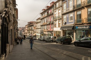 Een typische straat met trambaan en huizen die aan de buitenkant betegeld zijn.
